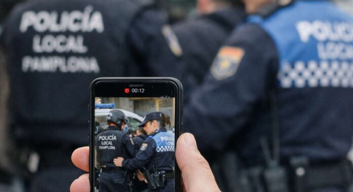 imagen ficticia de una persona grabando con su móvil unas actuaciones policiales