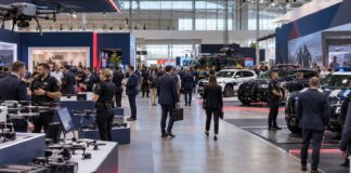 ExpoSecurity 2026: fechas, programa y entrada gratis en Madrid Recreación con IA de un pabellón de feria de seguridad privada y policial con stands y visitantes, ExpoSecurity 2026 Madrid